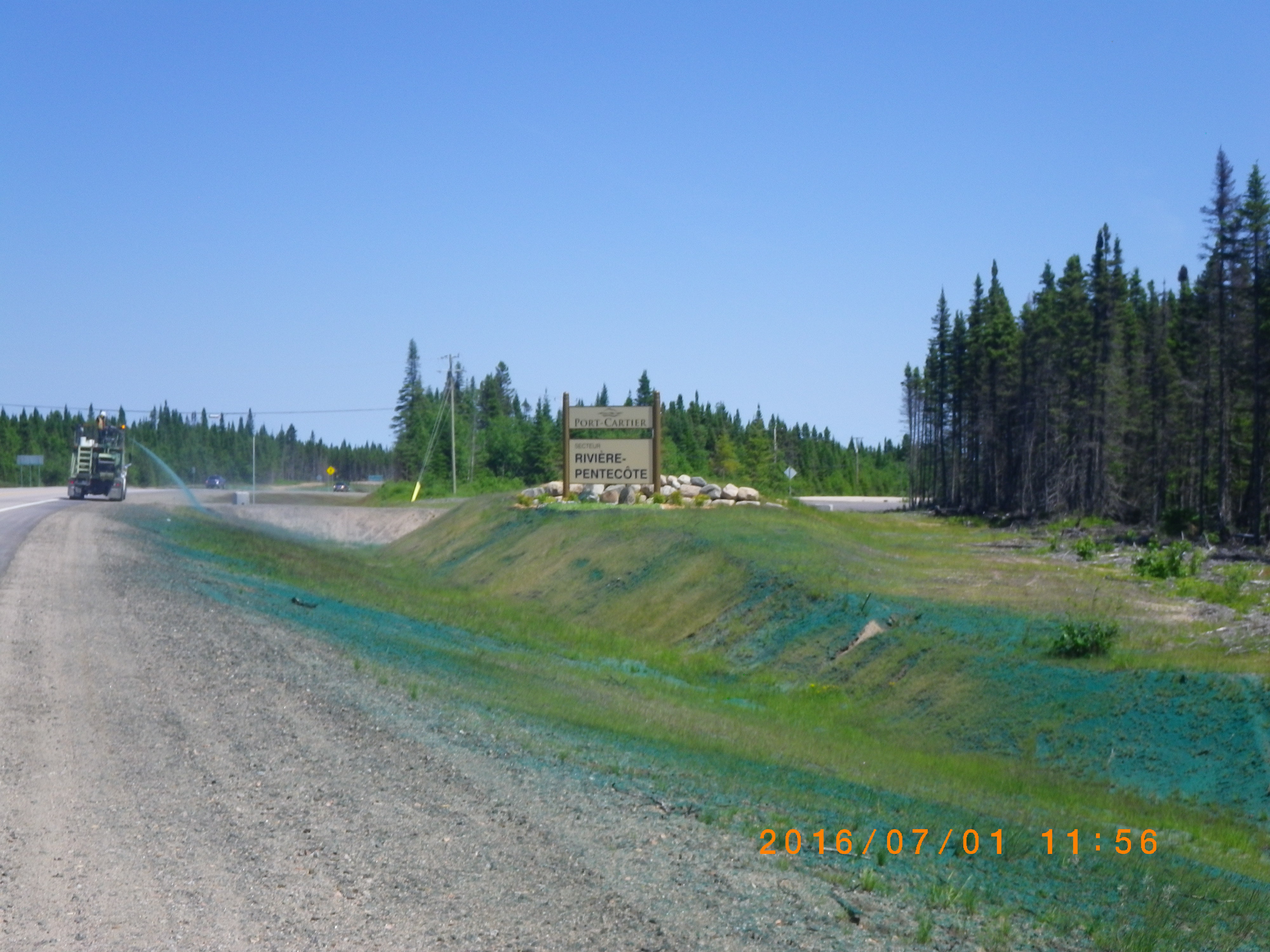 Correction de courbe dans le secteur de la rivière Riverin, à Rivière-Pentecôte – Un accès à la municipalité a été construit à partir de la nouvelle route 138. De l’ensemencement hydraulique est pulvérisé à l’aide d’un camion.